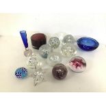 A collection of glass paperweights including those from Selkirk Glass, an amethyst coloured
