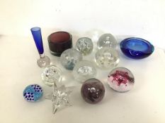 A collection of glass paperweights including those from Selkirk Glass, an amethyst coloured