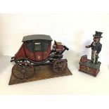 A novelty coin bank with Uncle Sam and a model of a Carriage on wooden plinth (26cm x 40cm x 20cm)