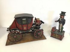 A novelty coin bank with Uncle Sam and a model of a Carriage on wooden plinth (26cm x 40cm x 20cm)