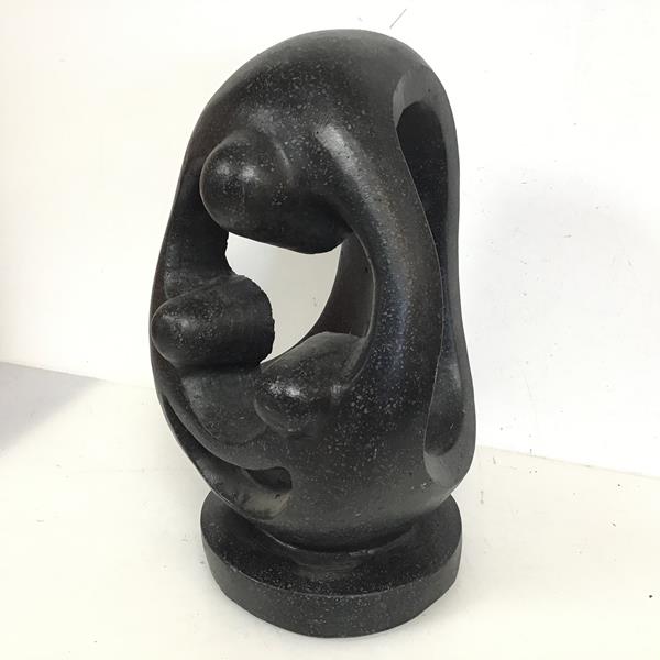 A composition stone abstract sculpture on circular base (43cm x 25cm x 27cm)