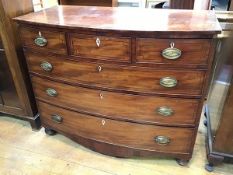 A Regency mahogany bow front chest with crossbanded top above three short drawers (central drawer