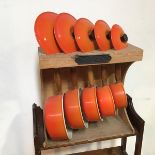 A set of five Le Creuset cast iron Volcanic pans with lids and wooden handles, on stand (largest: