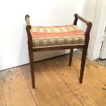 A 19thc stained beech piano stool with turned handles, with upholstered seat, on tapering straight