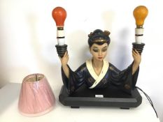 An unusual mid 20thc painted plaster table lamp in the form of a Japanese Woman her arms, each