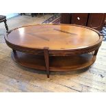 A cherrywood oval coffee table, with central crossbanded diamond inlay, the frieze fitted two