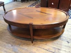 A cherrywood oval coffee table, with central crossbanded diamond inlay, the frieze fitted two