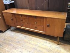 A 1960s teak side cabinet, fitted a pair of doors enclosing a shelved interior, flanked by a set