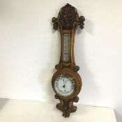 A 1920s oak wall barometer with carved finial and pendant (67cm x 20cm)