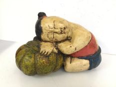 A Chinese carved wooden polychrome figure of a Young Child with Head Resting on Pumpkin (26cm x 37cm