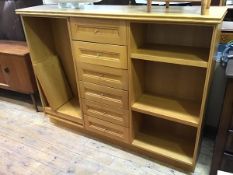 A modern oak bookcase with a central bank of six drawers, flanked by adjustable shelves on plinth