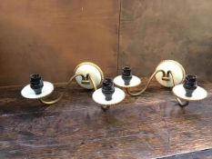 A pair of two arm ceramic and enamelled wall lights, each S scroll arm terminating in a drip tray (