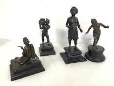 A set of four 1920s Burmese bronze figures including a Walking Man (25cm), a Water Carrier, Boy