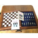 A Camelot chess set, the lift up mahogany game board over a fitted interior with Camelot themed