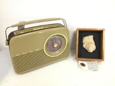 A Bush travel radio, model TR82/97 (28cm x 34cm x 10cm) and a cast of carved stone Angel's Head,