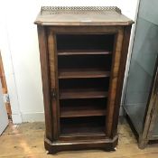 A Victorian walnut side cabinet, with brass gallery back, the single door lacking glass, the
