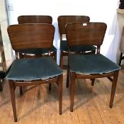 A set of four mid century mahogany side chairs, each with a rounded rectangular back above a teal