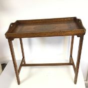An Anglo Indian brass and copper inlaid folding table with handles to side and removable cross