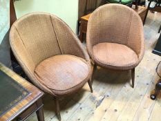 A pair of 1960s/70s tub chairs, in brown and orange upholstery, on splay turned tapering supports,