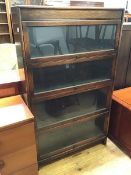 A 1920s/30s oak bookcase of four tiers with raising front glass doors, stamped John Miller, Leith