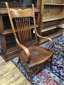 A 19thc open armchair with turned spindle back flanked by curved arms, on turned supports united