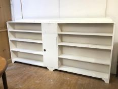 A large painted open bookcase with moulded ledge back, fitted central fall front cabinet above a