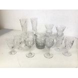A collection of cut crystal and cut glass drinking glasses including two champagne flutes, inscribed