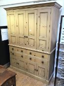 A large modern pine linen press fitted two hinged doors enclosing a shelved interior above an