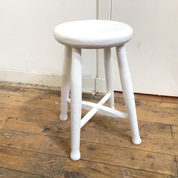 A white painted stool with circular seat on four turned supports united by stretchers (50cm x 30cm)