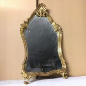 A modern rococo style mirror, the gilt frame with C scrolls and shell surmount (75cm x 34cm)