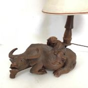 A Chinese carved hardwood table lamp in the form of an Ox with Rider (to top of lampholder: 34cm x