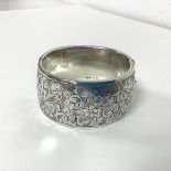A 1930s/40s Birmingham silver bangle with clasp and foliate decoration to one side (3cm x 6cm) (47.