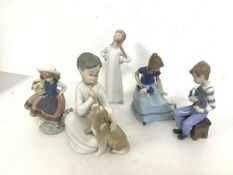 Three Lladro figures, Boy with Puppy, Girl with Flower basket and Sleepy Girl (21cm) and two Nao