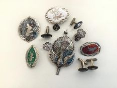 A group of Thai enamelled silver jewellery comprising five brooches, including a large peacock