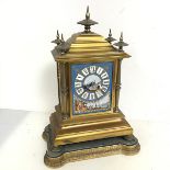 A 19thc French ormolu mantel clock, the stepped top with five finials above a central ceramic tile