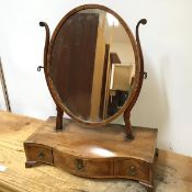 An Edwardian mahogany dressing table mirror, the oval glass on S scroll supports, on serpentine