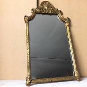 A wall mirror within a gilt frame, with seashell surmount and multiple C scrolls (69cm x 40cm)