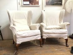 A pair of wing back Parker Knoll armchairs both in foliate pattern loose cover in ivory, on front