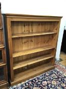 A modern pine open bookcase, fitted three adjustable shelves on plinth base (138cm x 126cm x 29cm)