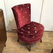 A modern bedroom chair with deep red multiple stylised flowerhead upholstery (77cm x 54cm x 42cm)