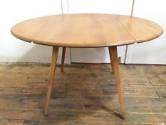 An elm Ercol drop leaf dining table with oval top on splay straight tapering supports (open: 71cm
