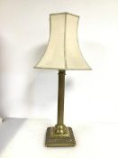 A large brass Classical column style lamp with Corinthian capital above a fluted column, on