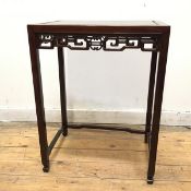 A Chinese hardwood side table with moulded top above a carved apron, on straight supports united