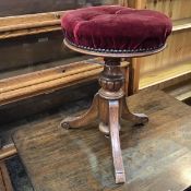 A Victorian piano stool with upholstered buttoned circular seat, on turned stem with tripod base