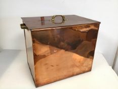 A metal box, the lift off lid with aperture, with brass handles to side and copper exterior (