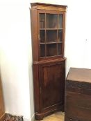 An early 19thc corner cabinet with walnut veneered frieze to cornice, the upper section with