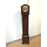 An oak 1920s grandmother clock with domed top above a metal dial with arabic numerals, with