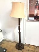 A mahogany standard lamp with turned body and leaf carving to base, on dished circular base (with