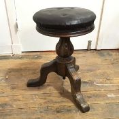 A 19thc oak piano stool, with circular leather padded seat, on baluster shaped stem and tripod