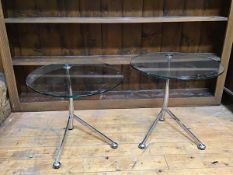 A near pair of modern glass and metal tables, the circular clear glass top on curved stem with